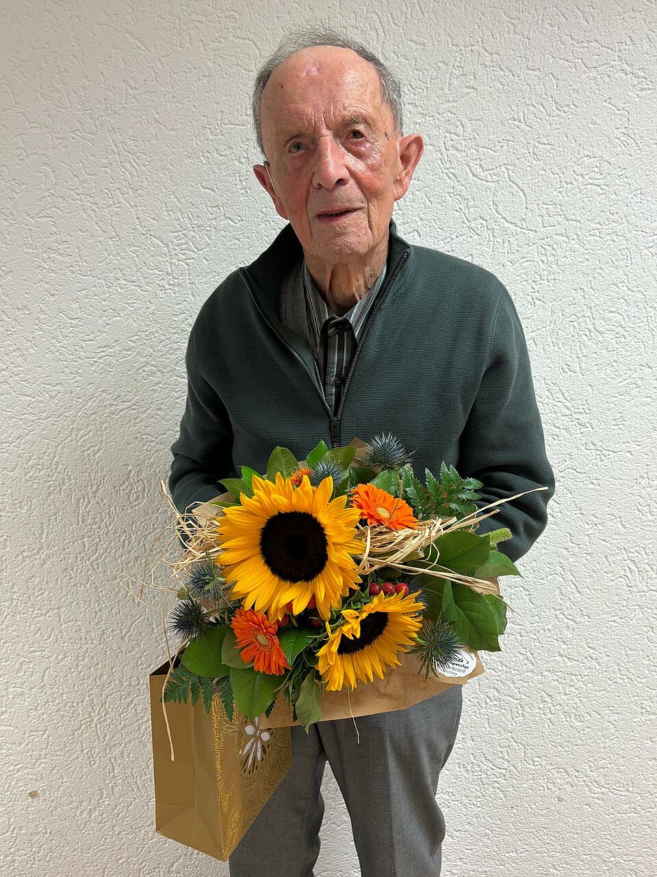 100 Jahre Lebensfreude Herr Theis mit einem Blumenstrauß